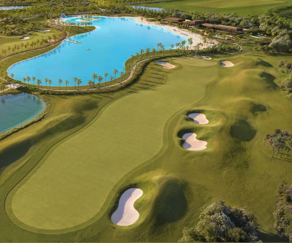 Vista aérea do campo de golf, com fairways ondulados e bunkers de areia clara