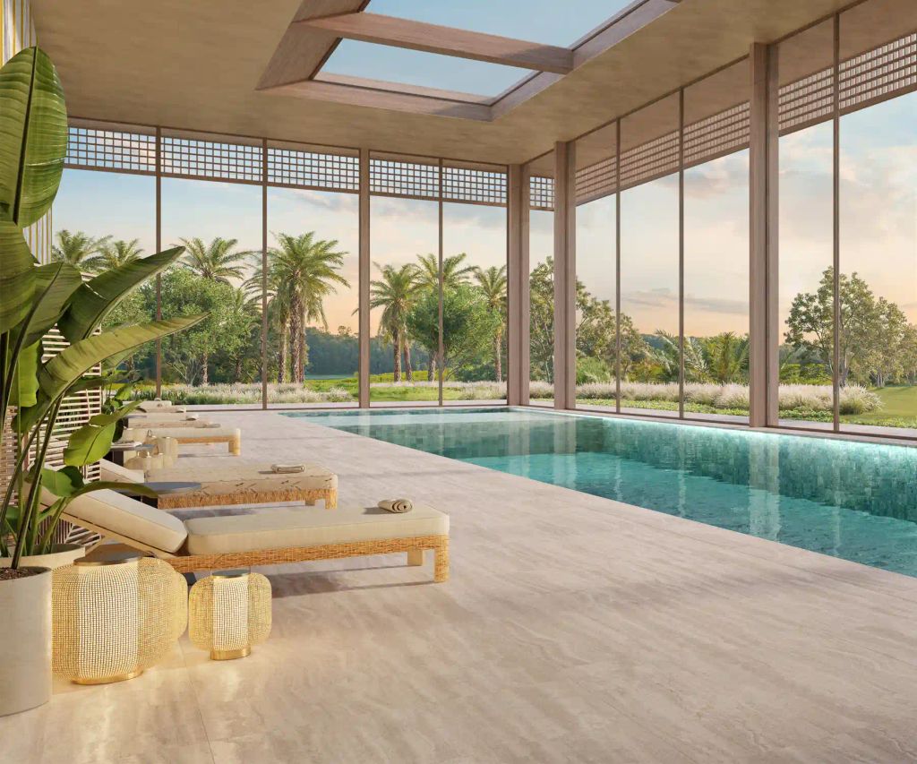 Piscina coberta do spa, com espreguiçadeiras e fachada de vidro voltada para o jardim